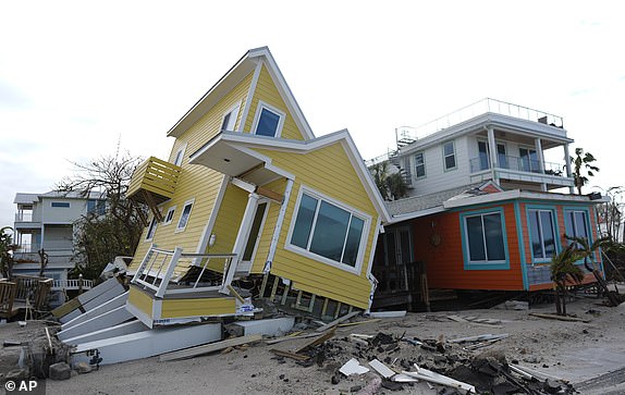 A house lies toppled off its stilts after the passage of Hurricane Milton, in Bradenton Beach on Anna Maria Island, Fla., Thursday, Oct. 10, 2024. (AP Photo/Rebecca Blackwell)