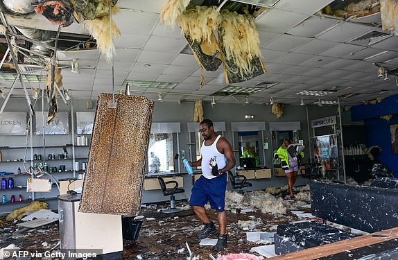 Employees collect some of their belongings from a beauty salon that was destroyed by the intense tornado that hit Cocoa Beach, Florida, on October 10, 2024. Hurricane Milton tore a coast-to-coast path of destruction across the US state of Florida, whipping up a spate of deadly tornadoes that left at least four people dead, but avoiding the catastrophic devastation officials had feared. (Photo by GIORGIO VIERA / AFP) (Photo by GIORGIO VIERA/AFP via Getty Images)