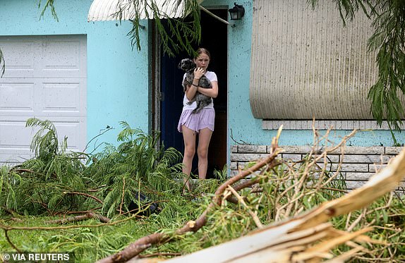 Mallory Tollett, 12, comforts her dog Maggie after a suspected tornado went through her family's property along Southeast Azimuth Way as Hurricane Milton bands move through Port Salerno, Florida, U.S., October 9, 2024. Crystal Vander Weit/USA TODAY NETWORK via REUTERS. THIS IMAGE HAS BEEN SUPPLIED BY A THIRD PARTY. NO RESALES. NO ARCHIVES.